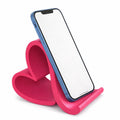 Pink heart-shaped phone stand holding a blue phone on a white background
